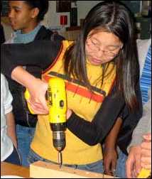 Girl holding power drill with both hands